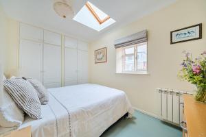 a white bedroom with a bed and a window at Easter, Folly Lane, Salcombe in Salcombe