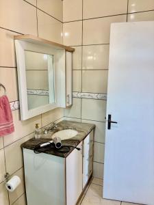 a small bathroom with a sink and a mirror at Casa próxima ao shopping Lages e a festa do pinhão in Lages