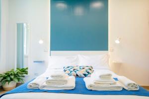 a bed with towels on it with a blue wall at Vacuna Pleasant Rooms in Naples
