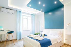 a blue bedroom with a bed with towels on it at Vacuna Pleasant Rooms in Naples