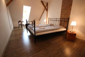 a bedroom with a black bed with a wooden floor at Ubytování Kroupa in Dolní Dunajovice