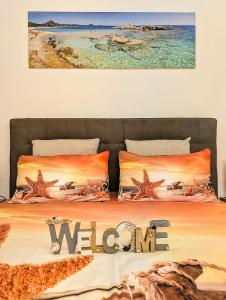 a bedroom with a bed with the words welcome at "SARDESIDENCE" Spiaggia Privata WiFi Parcheggio Riservato in Costa Rei