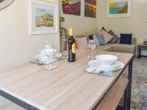 a table with a bottle of wine and two glasses at Rookmead Cottage in Yarmouth