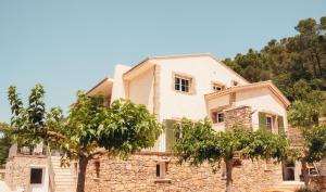 a large stone house with trees in front of it at Domaine du PIAOU "chambres & table d'hôte" in Le Val