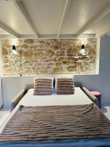 パリにあるIle saint Louis Notre Dame de Parisの石壁の客室の大型ベッド1台分です。