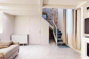 パリにあるIle saint Louis Notre Dame de Parisのソファと階段のあるリビングルーム