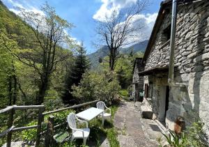 un tavolo e due sedie sul balcone di un edificio di Rustic on the Verzasca River a Corippo