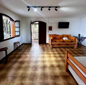 a living room with a bed and a television at Villaggio Harmonia Monte Verde in Camanducaia