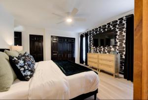 Un dormitorio con una cama, una cómoda y un televisor. en Ultimate Game Night Getaway Hot Tub, Arcade & Fun, en Oklahoma City
