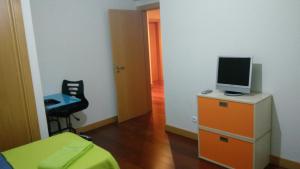 Dormitorio con cama y tocador con TV en Corcovada Lote 35, en Albufeira