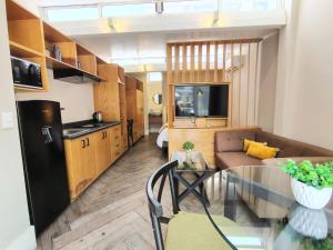 een keuken en een woonkamer met een glazen tafel bij CASA NIAGARA in Mexico-Stad