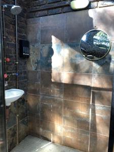 a bathroom with a mirror and a sink at African Paradise - Garden Glamping - Outdoor Shower in Benoni