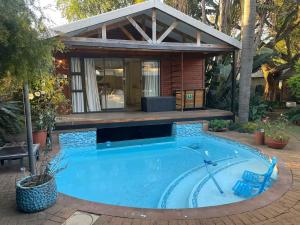 a house with a swimming pool in front of a house at African Paradise - Garden Glamping - Outdoor Shower in Benoni