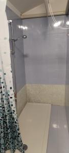 une douche avec une porte en verre dans une salle de bain dans l'établissement home sweet home, à Buia 6 autres photos