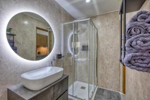 グジラにあるBoutique Apartment - Stylish Living By the Seaの洗面台と鏡のあるバスルーム +35枚の写真