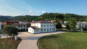 a large white house with a hill in the background at Soggiorno in villa - apt with kitchen and terrace in Gambellara