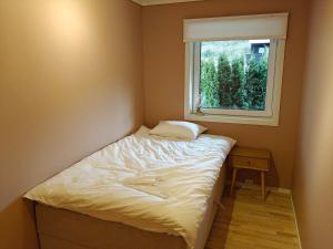 a small bedroom with a bed and a window at Hagekjeråsen 18 B in Lyngdal