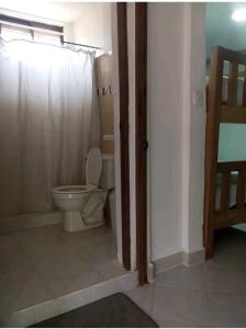 a bathroom with a toilet with a shower curtain at Cabaña el cielo in Lorica
