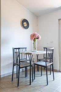 a dining room table with two chairs and a vase with flowers at My Toy Holiday Pompei in Pompei +26 photos