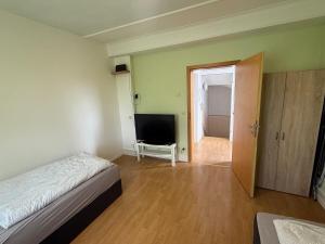 a bedroom with a bed and a flat screen tv at Wohnung in Troisdorf T05 in Troisdorf