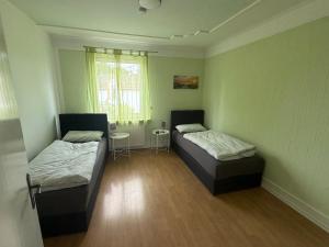 a room with two beds and a table and a window at Wohnung in Troisdorf T05 in Troisdorf