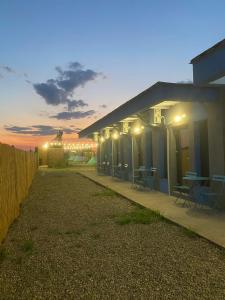 a house with a row of tables and chairs at night at Sea Side Camping in Vama Veche