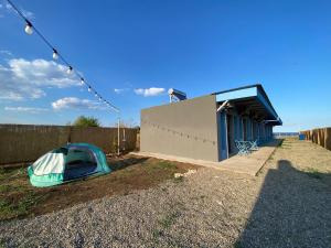 a tent on the ground next to a building at Sea Side Camping in Vama Veche