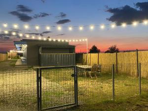 a grill on a fence with a table and lights at Sea Side Camping in Vama Veche +10 photos