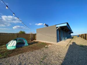 a tent on the ground next to a building at Sea Side Camping in Vama Veche