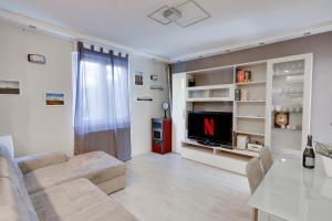 a living room with a couch and a television at La Casa di Mara con Piscina, Giardino, Parcheggio Privato a Sistiana in Sistiana