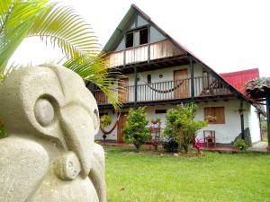 uma casa com uma estátua em frente em Hotel Alto de los Andaquies em San Agustín