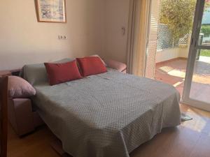 a bedroom with a bed with red pillows on it at APARTAMENTO URBANIZACION 1ºLINEA DE PLAYA NUDISTA in Vera +17 photos
