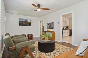 a living room with a couch and a ceiling fan at Charming Yellow Door House Steps from OU in Norman