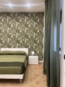 a bedroom with a bed with a floral wallpaper at affittacamerecoppola in Angri