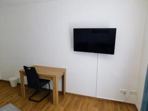 a room with a desk and a television on a wall at Apartment in Magdeburg-Salbke mit Balkon und WiFi in Magdeburg