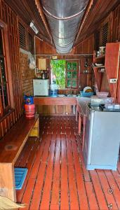 a kitchen with wood flooring and a kitchen with a stove at Thai Home Resort in Phra Ae beach +5 photos