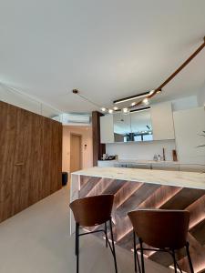 a kitchen with a counter and two chairs at Eurovea Tower, 27th floor apartment, free parking in Bratislava