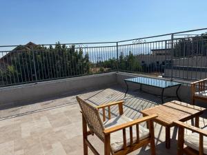 a patio with two chairs and tables on a roof at פשוט גולן in Bruchim Qela' Alon