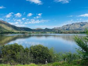 a view of a lake with mountains in the background at Alkimia del Río - Hogar, Arte, Piscina y Confort frente al Río in Potrero de los Funes