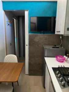 a kitchen with a stove and a table and a tv at Suite House in Sora +11 photos