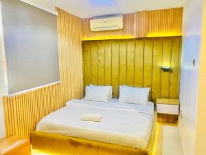 a bedroom with a bed with a wooden wall at 3Apartments in Lagos +13 photos