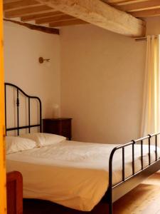 ein Schlafzimmer mit einem Bett in einem Zimmer in der Unterkunft Ferme des Millonets - petit gîte in Vienne-en-Arthies