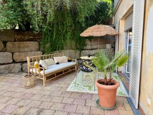 eine Terrasse mit einer Bank, einem Tisch und einem Sonnenschirm in der Unterkunft Nummer 11 in Kist