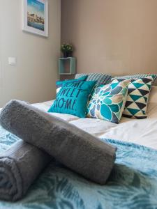 a bed with pillows on it in a bedroom at Studio Cosy La Fuye, proche gare, VELORA in Tours +12 photos