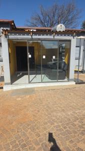 un bâtiment avec une porte vitrée avec un canapé à l'intérieur dans l'établissement Neethling 6 Guest House, à Johannesbourg