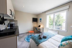 a bedroom with a bed and a kitchen with a window at Studio Cosy La Fuye, proche gare, VELORA in Tours