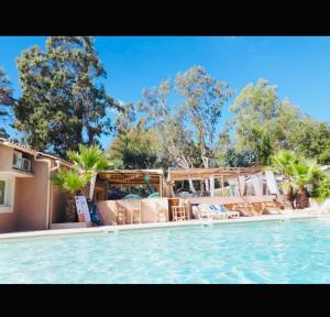 a swimming pool with chairs and a house at Mobilhome Camping piscine Hyères Plage in Hyères +5 photos