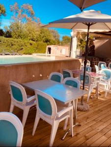 a table and chairs and an umbrella on a deck at Mobilhome Camping piscine Hyères Plage in Hyères