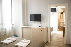 a room with a bed and a flat screen tv at Il corso in Norcia