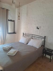 a bedroom with a bed with two towels on it at ZERVOU House in Batsi